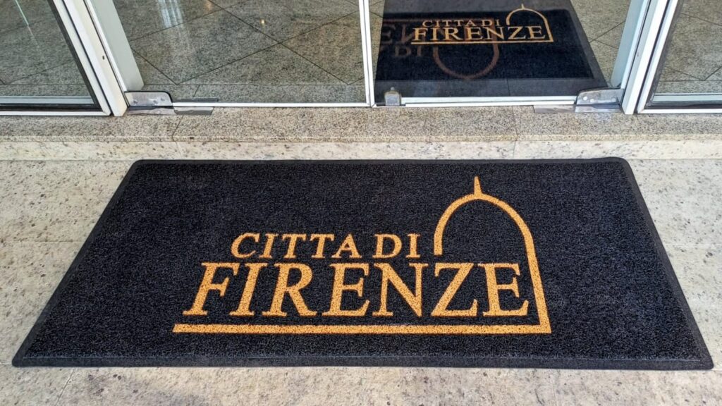 Imagem de tapete em fachada de entrada de hotel.